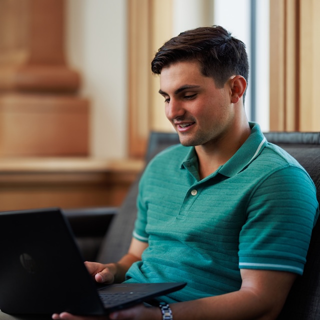 A male student looks at his laptop