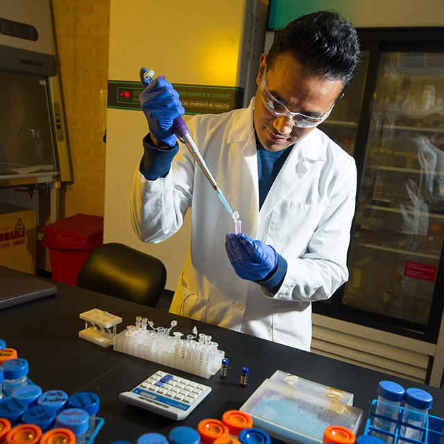 Man dispensing liquid into a plastic vial