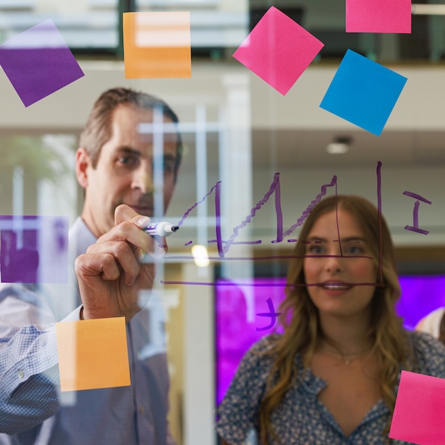 People looking at graph on translucent glass