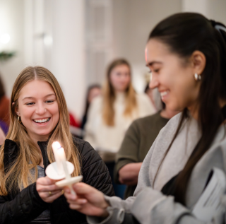 Two students light candles during TCU's annual candlelight service.  Two students light candles during TCU's annual candlelight service.